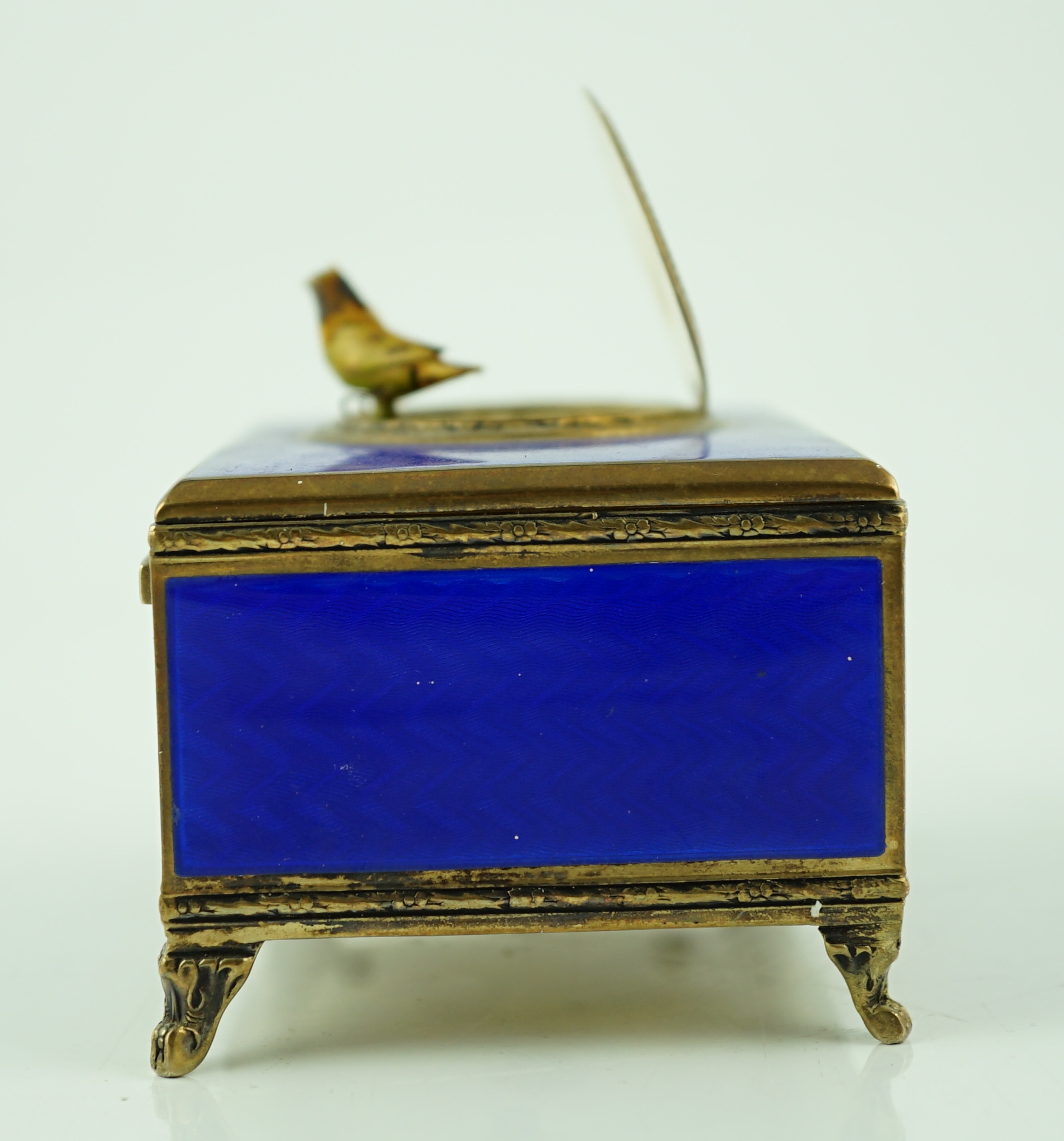 An early 20th century sterling silver gilt and blue guilloche enamelled rectangular singing bird box